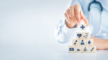 Hand,Arranging,Wood,Block,With,Healthcare,Medical,Icon.,Health,Insurance software development services